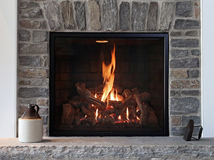 A clean, stone fireplace hearth, situated next to a television