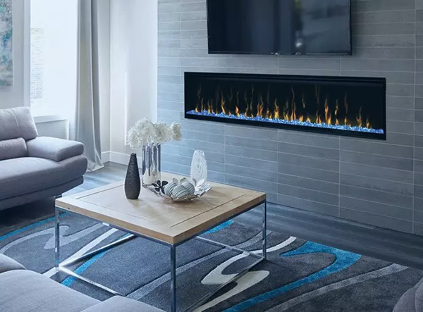An image of a fireplace in a living room with a small coffee table and a gray couch.