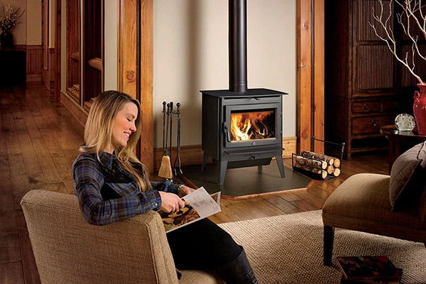 a woman reading by the fire