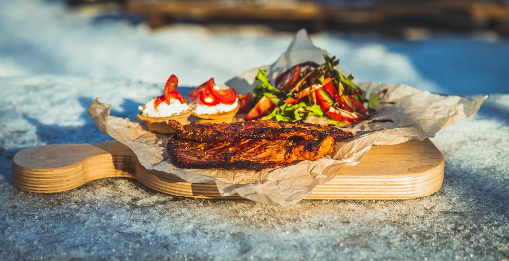 grilled foods on a wooden board in the snow