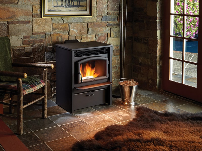 A Lopi pellet stove running, with a bucket of pellets next to it.